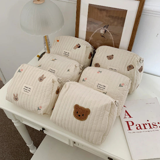 Trousse de toilette bébé - Complète et Pratique - rangement innovant - six variants posés sur un bureau