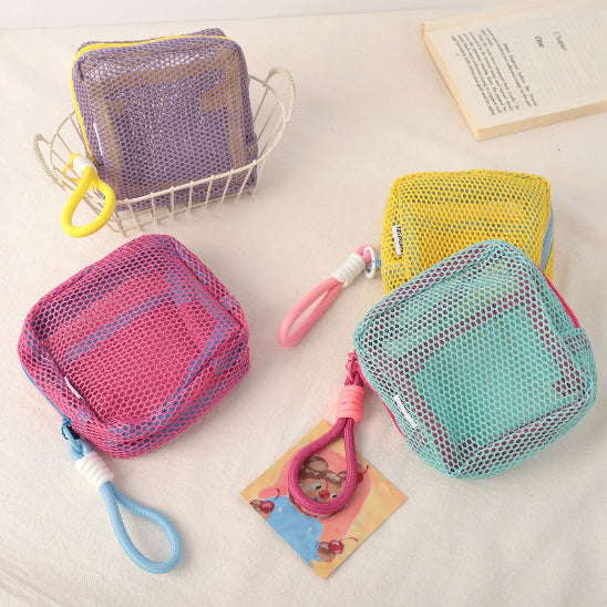 Trousse maquillage - Mesh transparente - Rangement innovant - vert - violet - rose - jaune - posées sur table