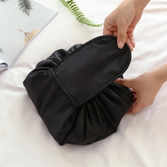 trousse maquillage pratique noir fermée posée sur nappe blanche rangement innovant
