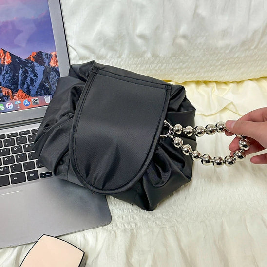 trousse maquillage pratique noir fermée à cÎté ordinateur rangement innovant