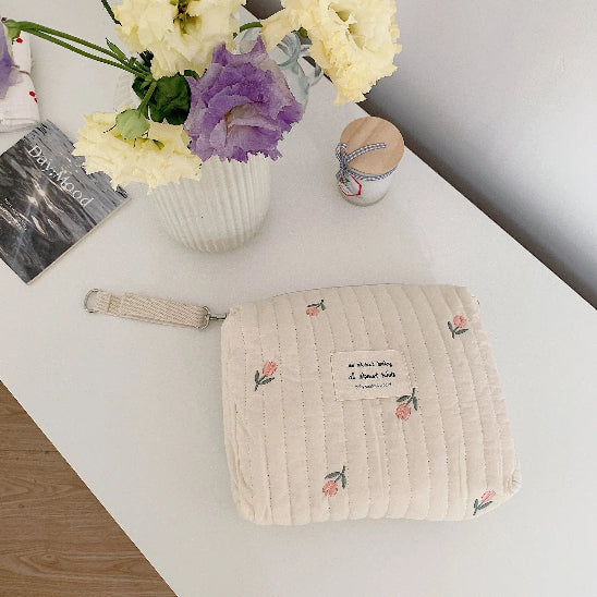 Trousse de toilette bébé - Complète et Pratique - rangement innovant - tulipes - posée sur la table