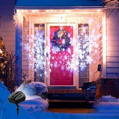 PROJECTEUR LED EXTERIEUR Flocons Féériques fixé dans la neige projection flocons neige sur porte entrée façade grande maison nuit tombée ciel bleu