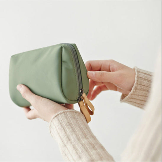 Trousse maquillage - Élégante - Rangement innovant - vert - portée par une main