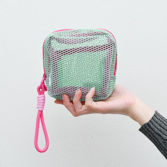 Trousse maquillage - Mesh transparente - Rangement innovant - vert portée par la main