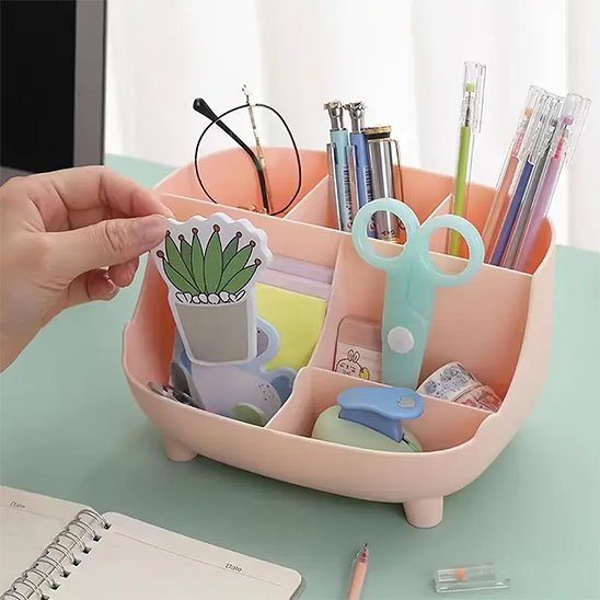 Organisateur de bureau ProEspace rose posé sur bureau vert devant rideau blanc