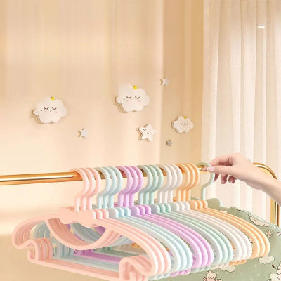 Cintre enfant plusieurs couleurs suspendus sur barre laiton horizontale chambre enfant