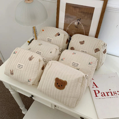 Trousse de toilette bébé - Complète et Pratique - rangement innovant - six variants posés sur un bureau