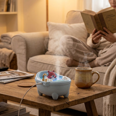 Humidificateur d air   Baignoire posé sur la table basse jeune femme faisant la lecture assise dans canapé