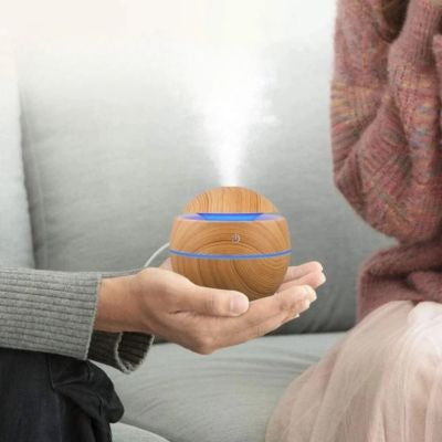 Humidificateur d air​ marron clair tenu dans les mains 