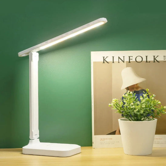 Lampe de bureau  LumiWork posée sur bureau côté revue mode