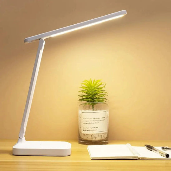 Lampe de bureau  LumiWork allumée posée sur bureau couleur jaune