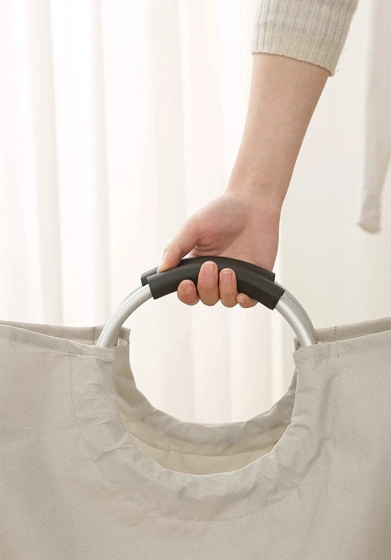 Panier-à-linge-pliable-spacieux-rangement-innovant-avec-une-main-tenant-les-poignées