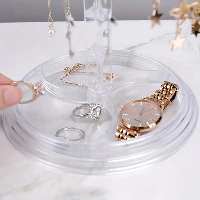 Porte bijoux  Élégant pratique transparent rempli de bijoux sur sa base posé sur support blanc