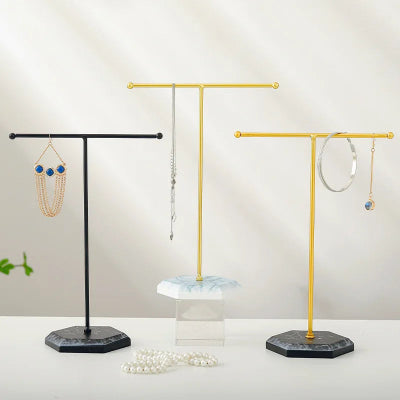 Porte bijoux Organisateur élégant noir blanc doré et noir doré portant des bijoux posés sur un comptoir 