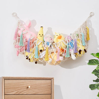 Rangement Peluche Coton Bohème beige rempli peluches accroché au mur dessus commode