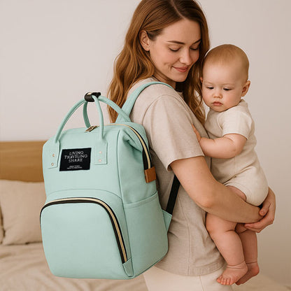 Sac-à-dos-à-langer-nori-rangement-innovant-avec-maman-et-bébé-vert-porté-sur-épaule