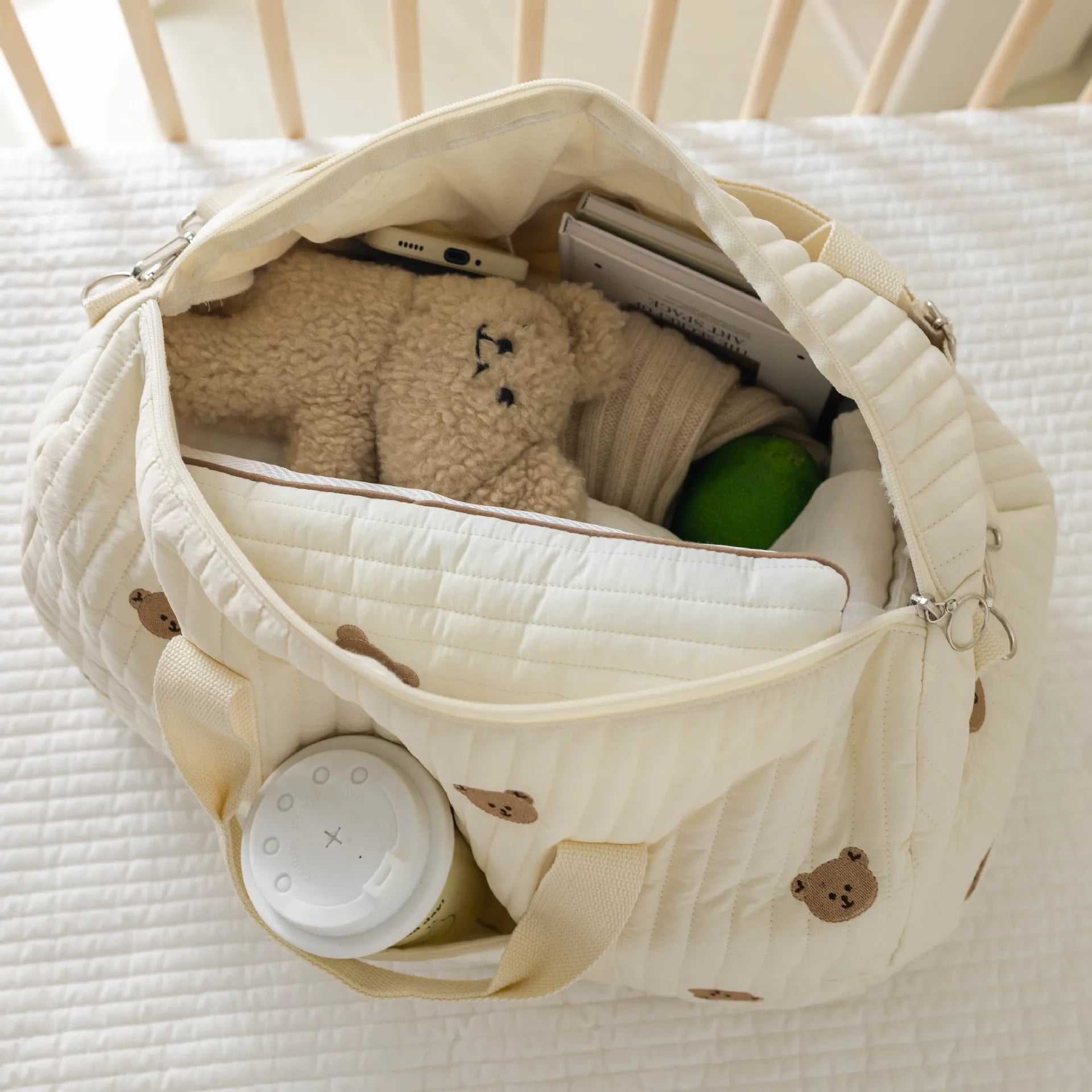 SAC-A-LANGER-BEBE-rangement-innovant-ourson-posé-sur-le-lit-ouvert-rempli-essentiels-pour-bébé