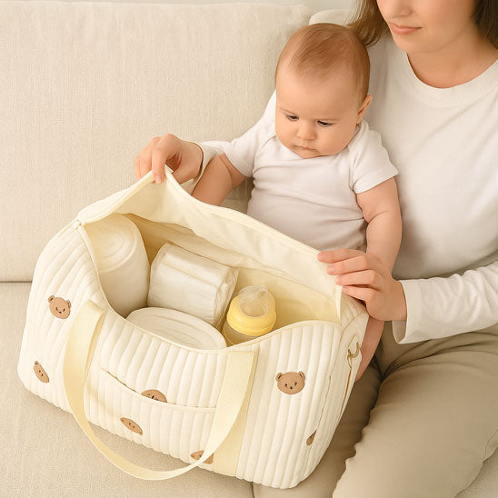 SAC-A-LANGER-BEBE-rangement-innovant-ourson-posé-sur-le-canapé-avec-le-bébé-et-la-maman