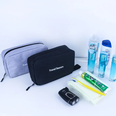Trousse de toilette suspendue Pratique Pliable gris noir fermées posées côté articles toilette