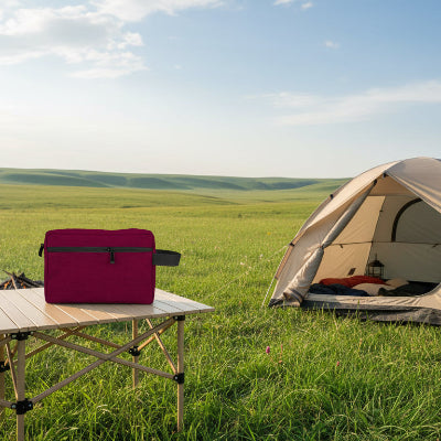 Trousse de toilette compartiment rouge posée sur table camping