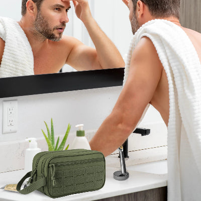 Trousse de toilette compartiment vert posée à côté d'un lavabo dans salle de bain