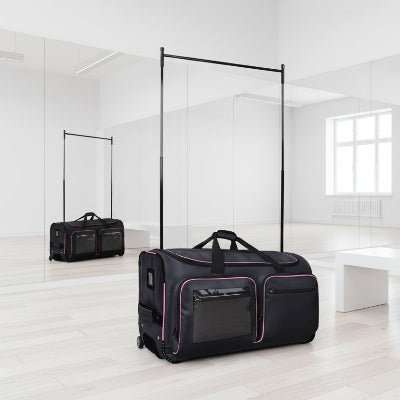 Valise penderie artistes pro noir posée dans salle de danse moderne