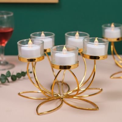 Bougeoir design cinq bougis allumées posé sur table à manger