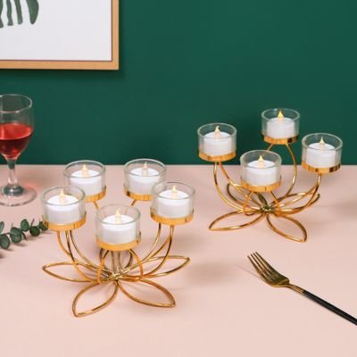 Bougeoir design bougies allumées posé sur table à manger