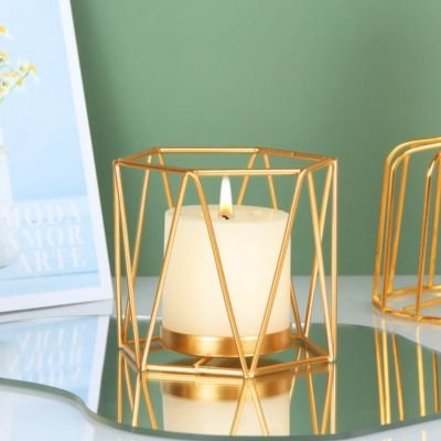 Bougeoir doré style cylindre posé sur table basse en verre