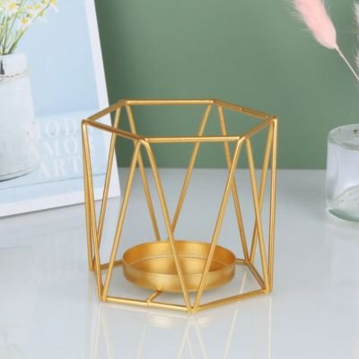 Bougeoir doré style cylindre posé sur table en verre blanc