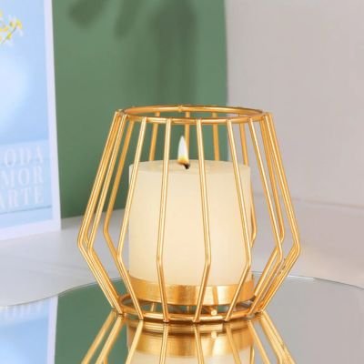 Bougeoir doré style lanterne posé sur table en verre