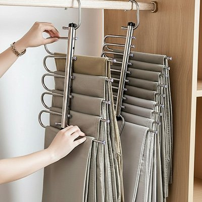 Cintre pantalon​ portant pantalons suspendus sur barre horizontale dressing