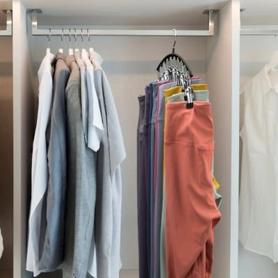 Cintre pantalon suspendu sur barre dans dressing