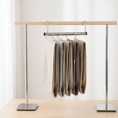 Cintre pantalon​ suspendu sur portant vêtement