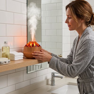Humidificateur d air​ marron tenu dans les mains par une utilisatrice