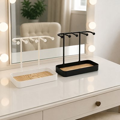 Porte bijoux noir et blanc posés devant miroir sur commode blanche
