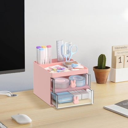 Organisateur de bureau Premium rose rempli fournitures scolaires posé sur bureau couleur beige