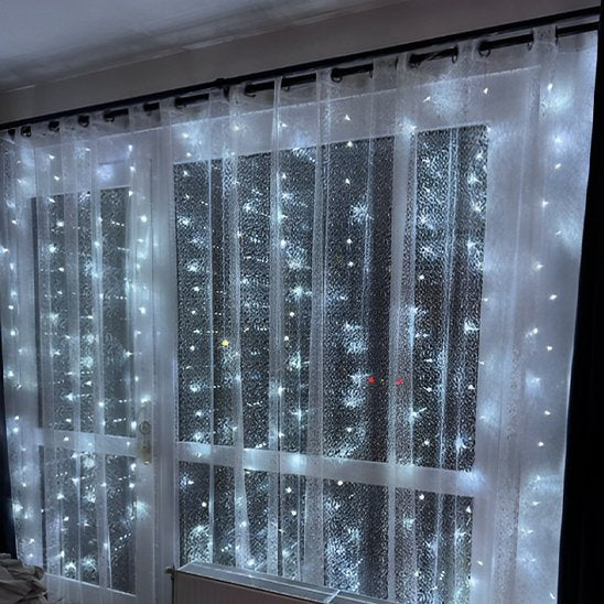 Guirlande Led Éco  Lumineuse lumière froide allumée derrière rideau blanc dans baie vitrée