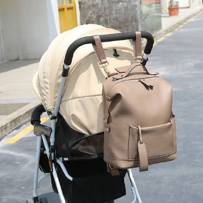 Sac à langer beige accroché sur poussette
