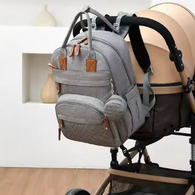 Sac à langer gris accroché sur poussette