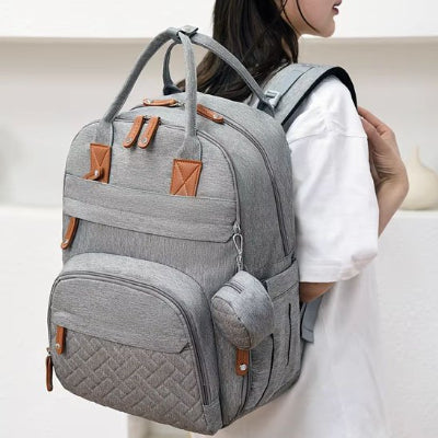 Sac à langer gris porté sur dos jeune maman